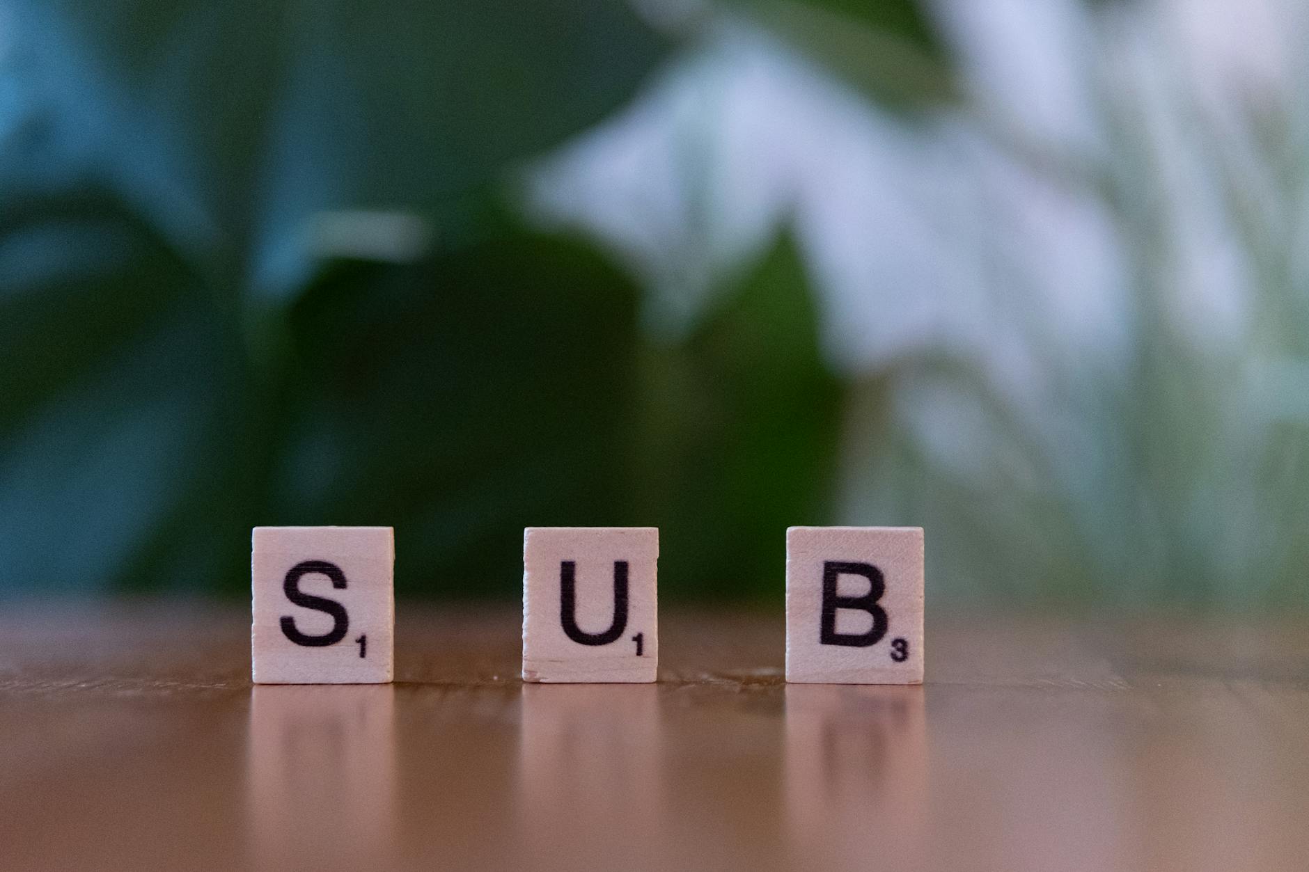 scrabble tiles spelling sub on wooden table
